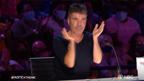 Simon Cowell clapping and giving a double thumbs up